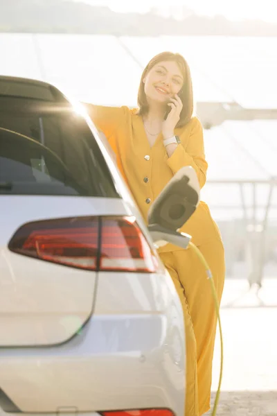 Positive Woman Have Talking Conversation Phone Her Electric Car Waits — Stock fotografie