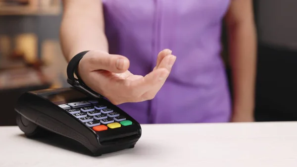 Akıllı saatinle temassız ödeme. Kablosuz ödeme konsepti. Yakın plan, kadın banka terminalinde sipariş vermek için Ukala Nakitsiz Cüzdan NFC teknolojisi kullanıyor. Cep telefonu ödemesi.