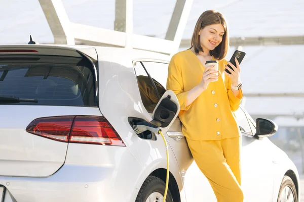 Běloška Používající Chytrý Telefon Čekající Napájení Připojit Elektrickým Vozidlům Pro — Stock fotografie