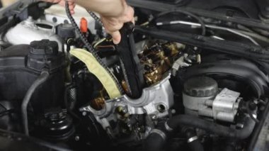 Car mechanic repair the engine in a car service. Unrecognizable mechanic repairing automobile motor using tool. Auto master fixing engine from vehicle. Repairer working in garage or workshop.