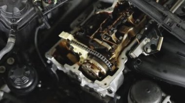 Unrecognizable mechanic repairing automobile motor using tool. Auto master fixing engine from vehicle. Repairer working in garage or workshop. Car mechanic repair the engine.