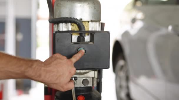 Man Hand Car Mechanic Press Switch Car Lift Machine Goes — Vídeo de Stock