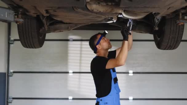 Handsome Professional Car Mechanic Working Vehicle Lift Service Repairman Using — Stockvideo