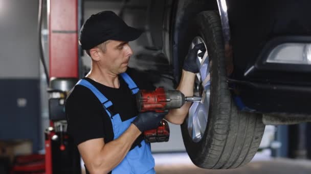 Car Mechanic Replacing Car Wheel Lifted Automobile Repair Service Station — Vídeos de Stock