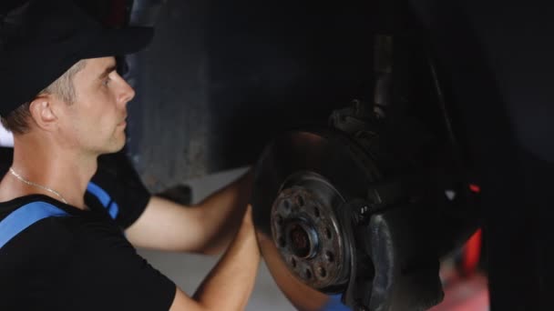 Caucasian Good Looking Mechanic Man Gloves Blue Coveralls Repairing Wheel — Wideo stockowe