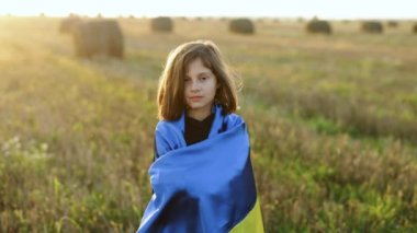 Ukrayna bayrağı taşıyan Ukraynalı küçük bir kızın portresi. Ukrayna 'ya destek. Vatansever elbiseli bir kız. Ukrayna 'da savaş. Savaşı durdurun. Ukraynalı bir kadın ülkesinin sümüklüböceğini elinde tutuyor..