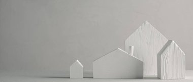 Gri arka planda beyaz ahşap oyuncak evler. Minimalist İskandinav dekoratif tasarımı