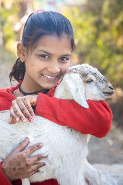 Uttarakhand yakınlarındaki köyde keçi tutan Hintli bir kızın portresi.