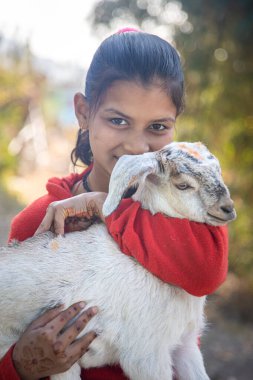 Uttarakhand yakınlarındaki köyde keçi tutan Hintli bir kızın portresi.