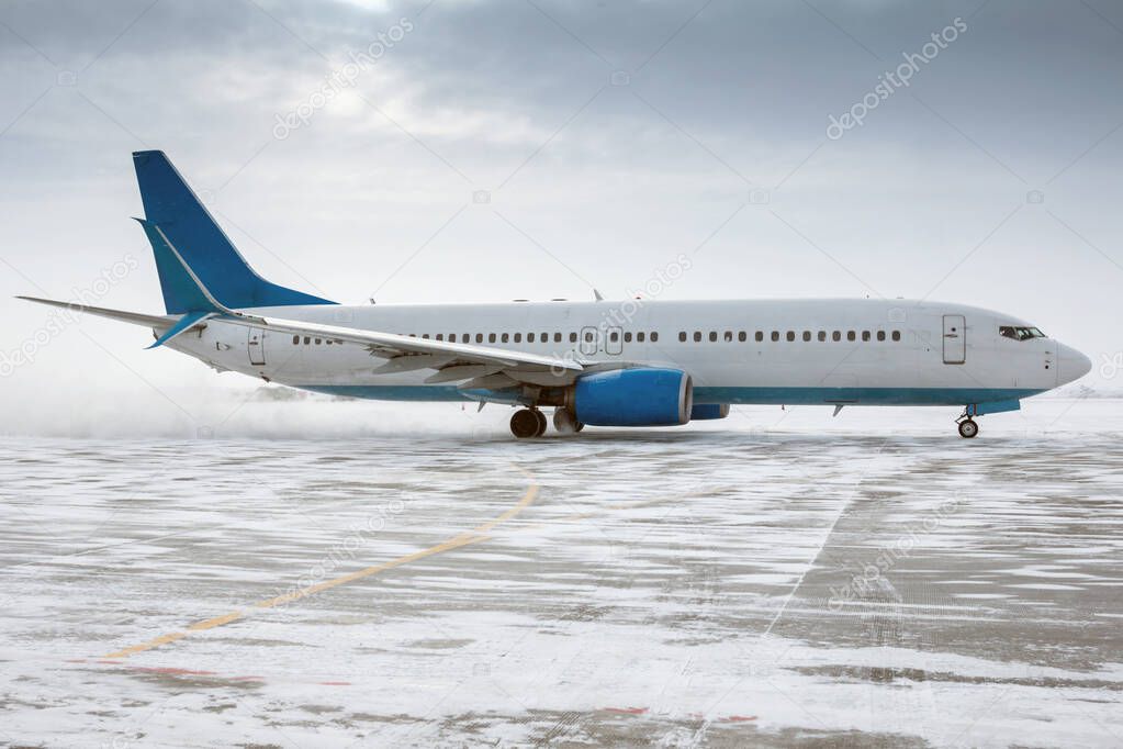 Taxiing of a passenger airplane on the airport apron in a snow storm