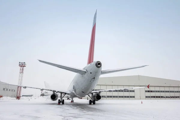 Białe Samoloty Pasażerskie Pobliżu Hangaru Lotniczego Chłodną Zimową Pogodę — Zdjęcie stockowe