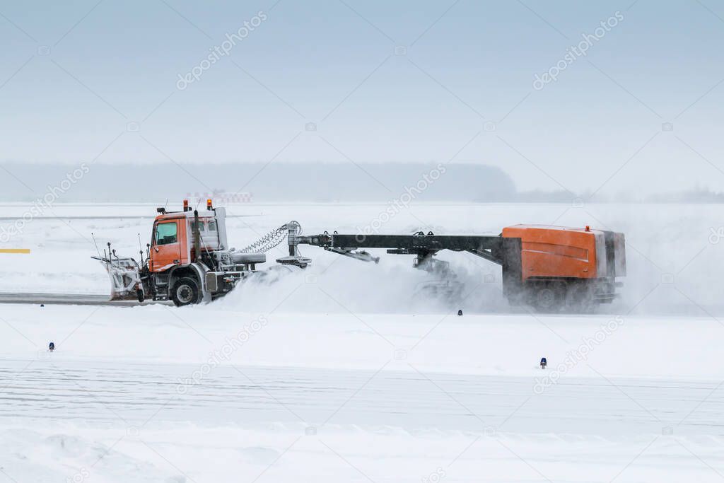 Snowblower cleans airport taxiway in a blizzard