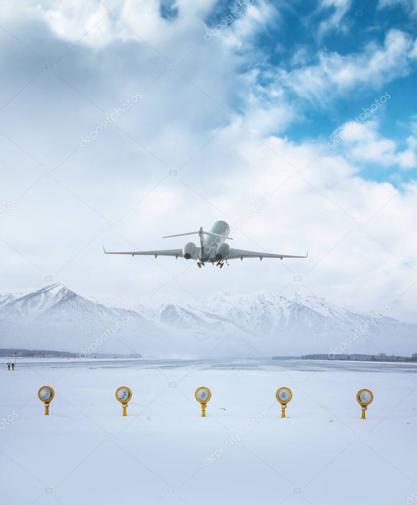 Modern executive business jet take off from airport runway against the backdrop of picturesque snow-capped mountains