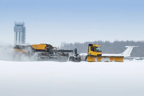 Airfield snow removal truck cleaning the runway at the airport in a severe blizzard