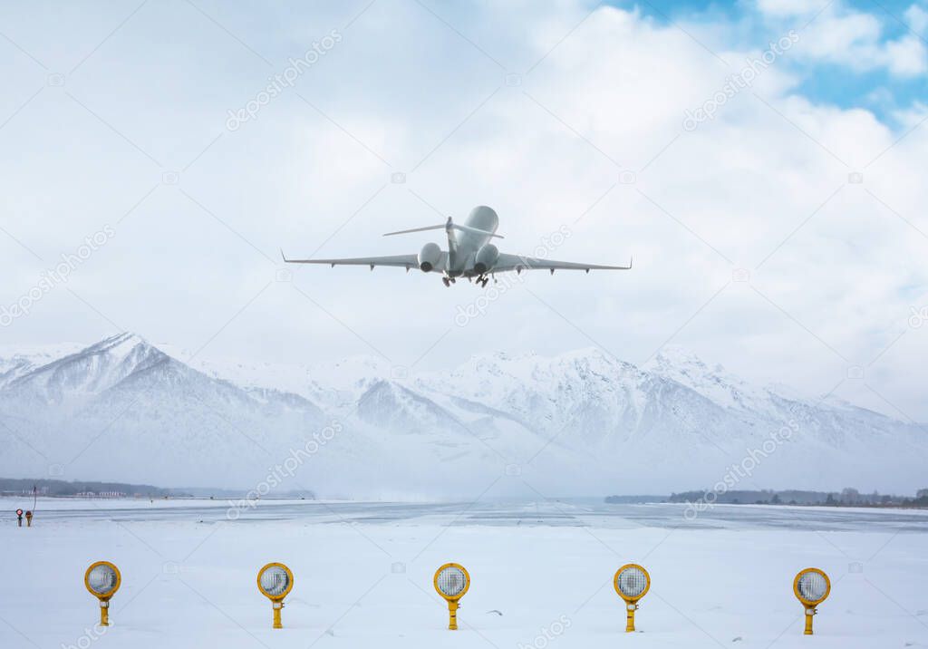 Modern business jet take off from airport runway against the backdrop of scenic snow-capped mountains