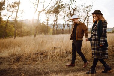 Sonbahar parkında yürüyen genç bir çift. Birlikte eğleniyoruz. Aşk hikayesi. Sonbahar stili.