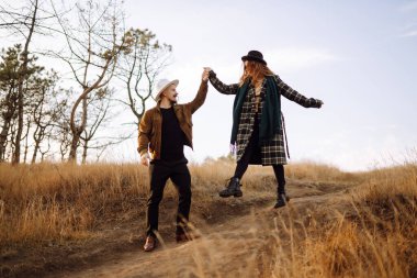 Sonbahar parkında yürüyen genç bir çift. Birlikte eğleniyoruz. Aşk hikayesi. Sonbahar stili.