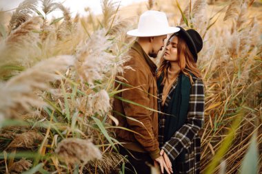 Sonbahar parkında yürüyen genç bir çift. Birlikte eğleniyoruz. Aşk hikayesi. Sonbahar stili.