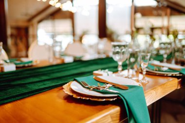 Restorandaki ziyafet masası, ziyafetten önceki hazırlık. Zümrüt renkli çiçekçilerin işi. Düğün, doğum günü, parti, etkinlik konsepti.