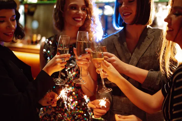手に輝く輝き 若い友人は新年を祝い ドリンクと一緒に優しい光とガラスを保持しています 冬の休日 パーティー ライフスタイルの概念 — ストック写真