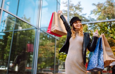 Alışveriş yapan genç bayan. Alışveriş yaptıktan sonra şehirde dolaşan şık bir kadın. Kara Cuma, satış, tüketici, yaşam tarzı konsepti.