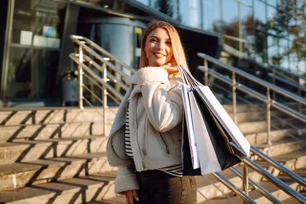 Alışverişten sonra genç bir kadın. Kara Cuma. Tüketim, alım, satış, yaşam tarzı, turizm ve mutlu insanlar konsepti.