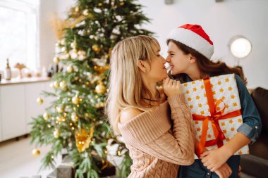Mutlu anne ve tatlı kızı hediye değiş tokuşu yapıyor. Mutlu Noeller ve mutlu tatiller.