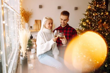 Genç çift Noel 'i dekore edilmiş evde kutluyor. Romantik bir gün. Kış tatili.