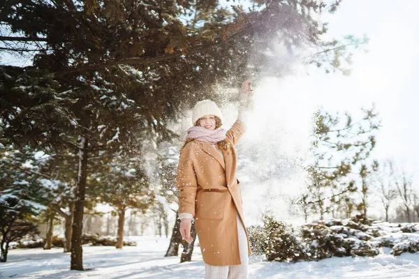 Mujer en ropa de invierno en el parque cubierto de nieve