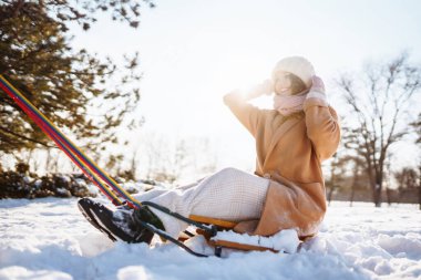 Genç bir çift kışın karlı ormandaki bir kızakta eğleniyor ve yuvarlanıyor. Doğa, tatiller, seyahat kavramı.