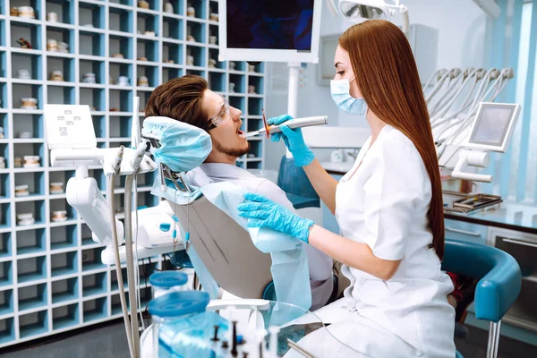 歯科処置中の歯医者の椅子の若い男 歯のケア予防の概要 健康な歯と薬の概念 — ストック写真