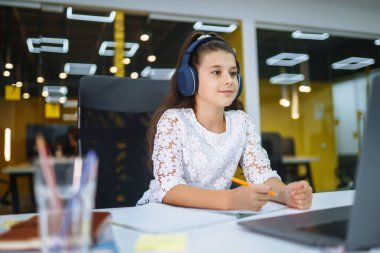 Online education. School girl using laptop computer studying through online e-learning system during quarantine. Covid-2019.