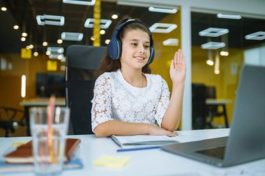 Online education. School girl using laptop computer studying through online e-learning system during quarantine. Covid-2019.