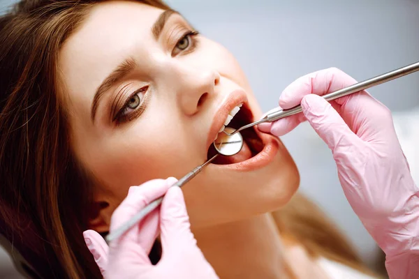 歯科処置中の歯医者の椅子の若い女性 現代の診療所で患者の歯を調べる歯科医 健康な歯と薬の概念 — ストック写真