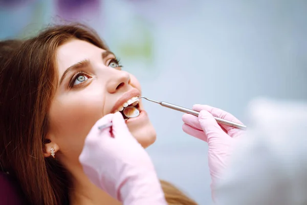 歯科処置中の歯医者の椅子の若い女性 現代の診療所で患者の歯を調べる歯科医 健康な歯と薬の概念 — ストック写真