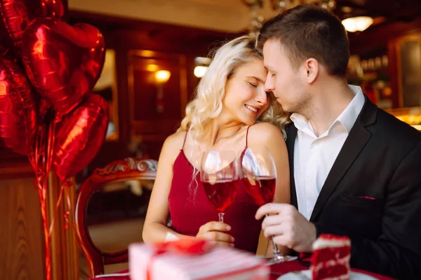 情人节的概念 交换礼物 美丽的年轻夫妇在餐馆庆祝情人节 亲吻和享受在一起的时光 — 图库照片