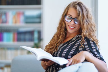 Evde dizüstü bilgisayarla çalışan genç bir kadın. Serbest çalışan ve evde karantinada çalışırken notlar alan biri. Eğitim çevrimiçi.