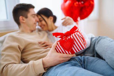 Sevgililer Günü konsepti. Sevgililer birbirlerine hediyeler verir. Evde Sevgililer Günü 'nü kutlayan genç bir çift..