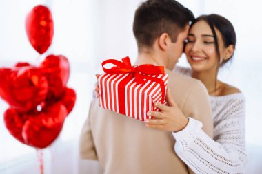 Sevgililer Günü konsepti. Sevgililer birbirlerine hediyeler verir. Evde Sevgililer Günü 'nü kutlayan genç bir çift..