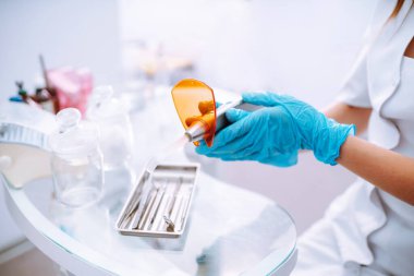 Dişçinin elindeki aletler. Diş tedavisi için steril diş aletleri. Sağlıklı diş ve ilaç konsepti.