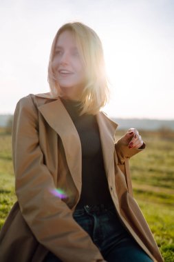 Genç kadın güneşli bir bahar gününün tadını çıkarıyor. İnsanlar, yaşam tarzı, seyahat, doğa ve tatil kavramı.