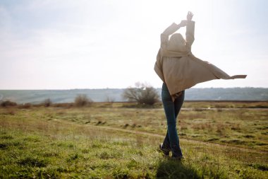 Genç kadın güneşli bir bahar gününün tadını çıkarıyor. İnsanlar, yaşam tarzı, seyahat, doğa ve tatil kavramı.