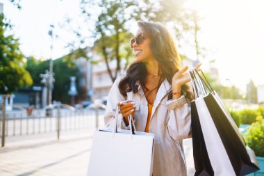 Young woman after shopping on the city street. Purchases, black friday, discounts, sale concept. 