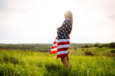 Genç bir kadın gururla elinde Amerikan bayrağını sallıyor. 4 Temmuz. 4 Temmuz 'da. Özgürlük için. Vatansever bayram. Bağımsızlık Günü.