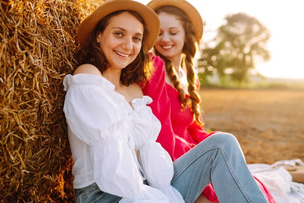 两个年轻女子在干草堆附近摆姿势 时尚的概念 放松和生活方式 夏季概念 — 图库照片