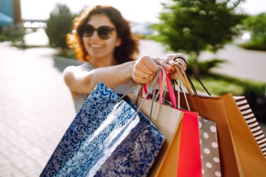 Shopping time. Young woman with shopping bags near the mall. Consumerism, sale, purchases, shopping, lifestyle concept. Summer.