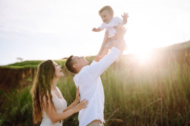Father, mother and child resting on the beach. Young family  are having fun on summer vacation. Travel,  nature, active lifestyle,  resort concept.