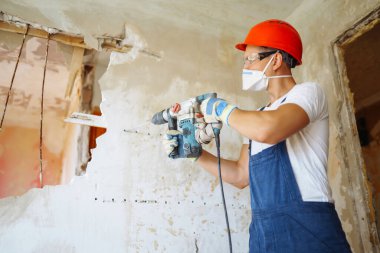 Klima giysisindeki tamirci aletleri tutuyor. Daire onarımı ve yenileme konsepti.