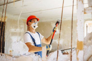 Klima giysisindeki tamirci aletleri tutuyor. Daire onarımı ve yenileme konsepti.