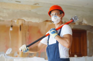 Klima giysisindeki tamirci aletleri tutuyor. Daire onarımı ve yenileme konsepti.